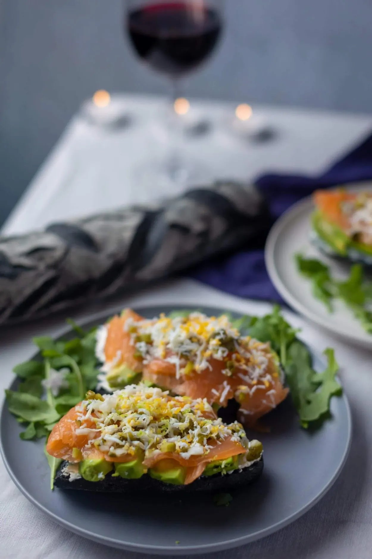 Tostadas de pan negro con aguacate, salmón ahumado y huevo rallado en un plato